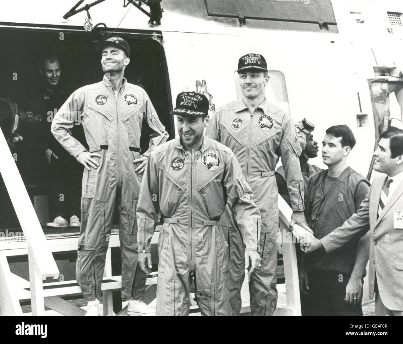 (April 17, 1970) The crew of the Apollo 13 mission step aboard the U.S.S. Iwo Jima, prime recovery ship for the mission, following splashdown and recovery operations in the South Pacific. Exiting the helicopter, which made the pick-up some four miles from the Iwo Jima are (from left) astronauts Fred. W. Haise, Jr., lunar module pilot; James A. Lovell Jr., commander; and John L. Swigert Jr., command module pilot. The Apollo 13 spacecraft splashed down at 12:07:44 pm CST on April 17, 1970.  Image # : 70-H-641 Stock Photo