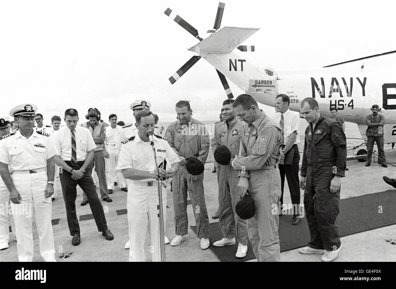 Commander Philip Eldredge Jerauld (at microphone), ship's chaplain for U.S.S. Iwo Jima, offers a prayer of thanks for the safe return of the Apollo 13 crew members soon after they arrived aboard the recovery ship. Standing in the center of the picture, from the left, are astronauts James A. Lovell Jr., Commander; Fred W. Haise Jr., Lunar Module Pilot; and John L. Swigert Jr., Command Module Pilot. The Apollo 13 Command Module &quot;Odyssey&quot; splashed down at 12:07:44 p.m. (CST), April 17, 1970, to conclude safely a perilous space flight. The three astronauts were picked up by helicopter an Stock Photo
