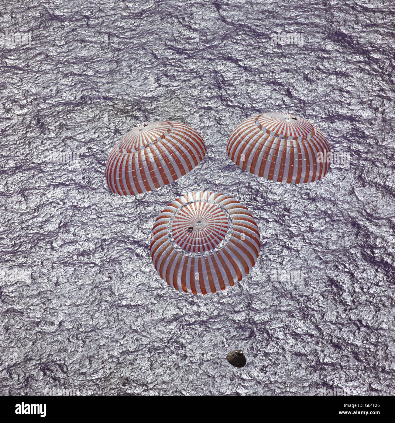 The Apollo 16 command module, with astronauts John W. Young, Thomas K. Mattingly II and Charles M. Duke Jr. aboard, nears splashdown in the central Pacific Ocean to successfully conclude a lunar landing mission. This overhead picture was taken from a recovery aircraft seconds before the spacecraft hit the water. The splashdown occurred at 290:37:06 ground elapsed time at 1:45:06 a.m. (CST), April 27, 1972, at coordinates of 00:43.2 degrees south latitude and 156:11.4 degrees west longitude, a point approximately 215 miles southeast of Christmas Island.  Image # : S72-36287 Stock Photo