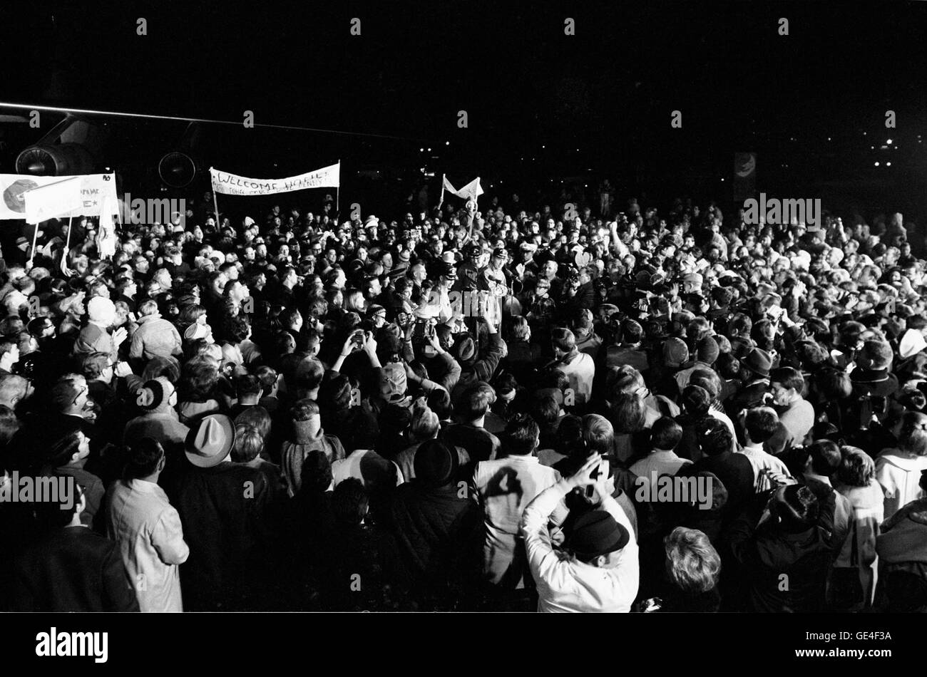 Although it was past 2 a.m., a crew of more than 2,000 people were on hand at Ellington Air Force Base to welcome the members of the Apollo 8 crew back home. Astronauts Frank Borman, James A. Lovell Jr., and William A. Anders had just flown to Houston from the pacific recovery area by way of Hawaii. The three crewmen of the historic Apollo 8 lunar orbit mission are standing at the microphones in center of picture.  Photo Number: S69-16402  Date: December 29, 1968 Stock Photo