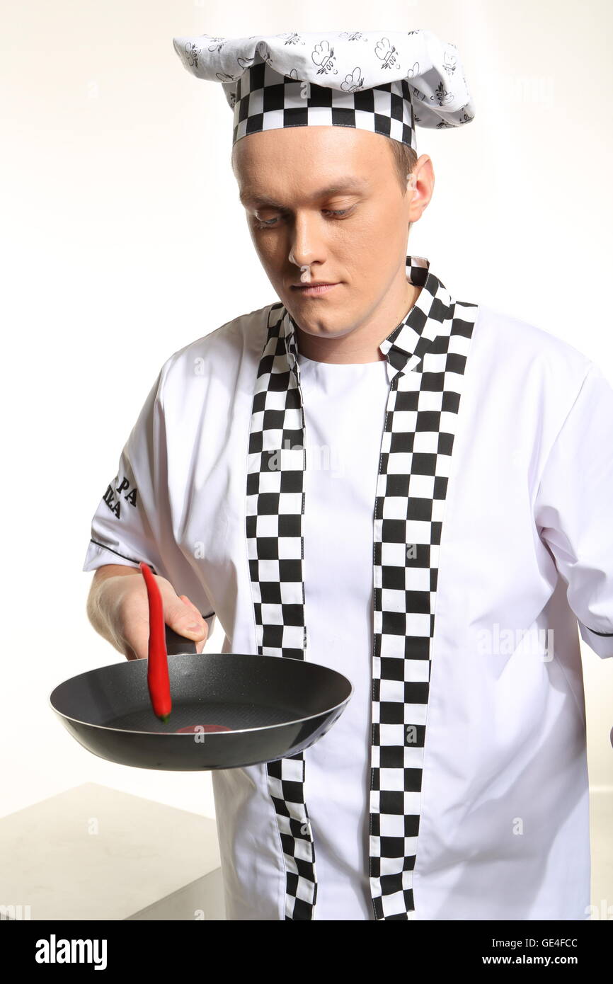 Portrait of young chef in uniform acrid chilli. Stock Photo