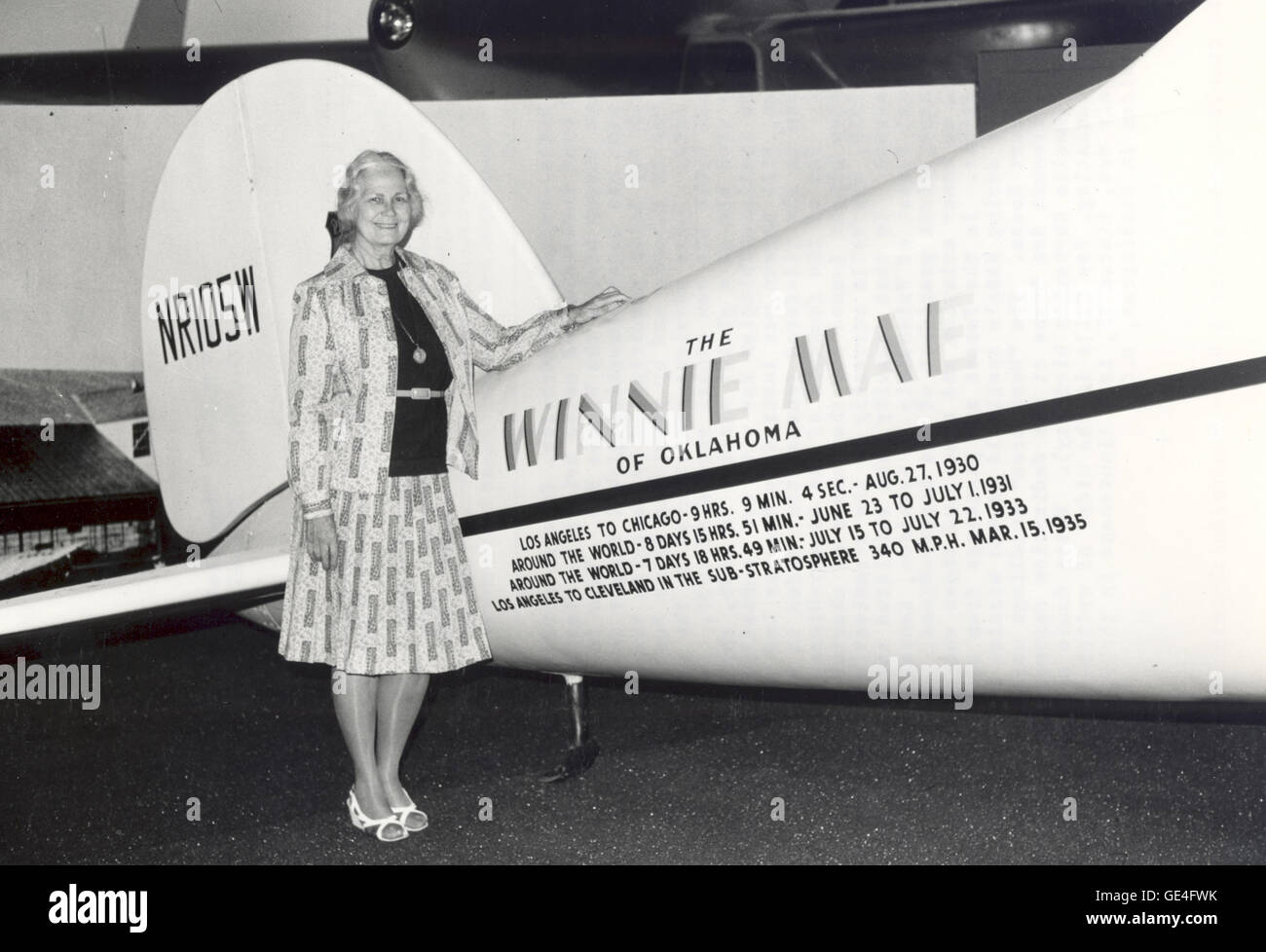 (1976) Fay Gillis Wells, writer, broadcaster, foreign correspondent, sailor, designer of boat interiors and noted aviatrix, stands in the National Air and Space Museum beside the Winnie Mae. This is the plane in which Wiley Post made his record-breaking global flight in 1933. Fay Wells participated in Posts achievement by managing the fuel dumps for the Winnie Mae in Siberia and by providing Wiley Post with the maps and navigation data. These services contributed to the success of the flight by which Post broke his own global record of 1931. Invited by Wiley Post to fly with him on a global mi Stock Photo