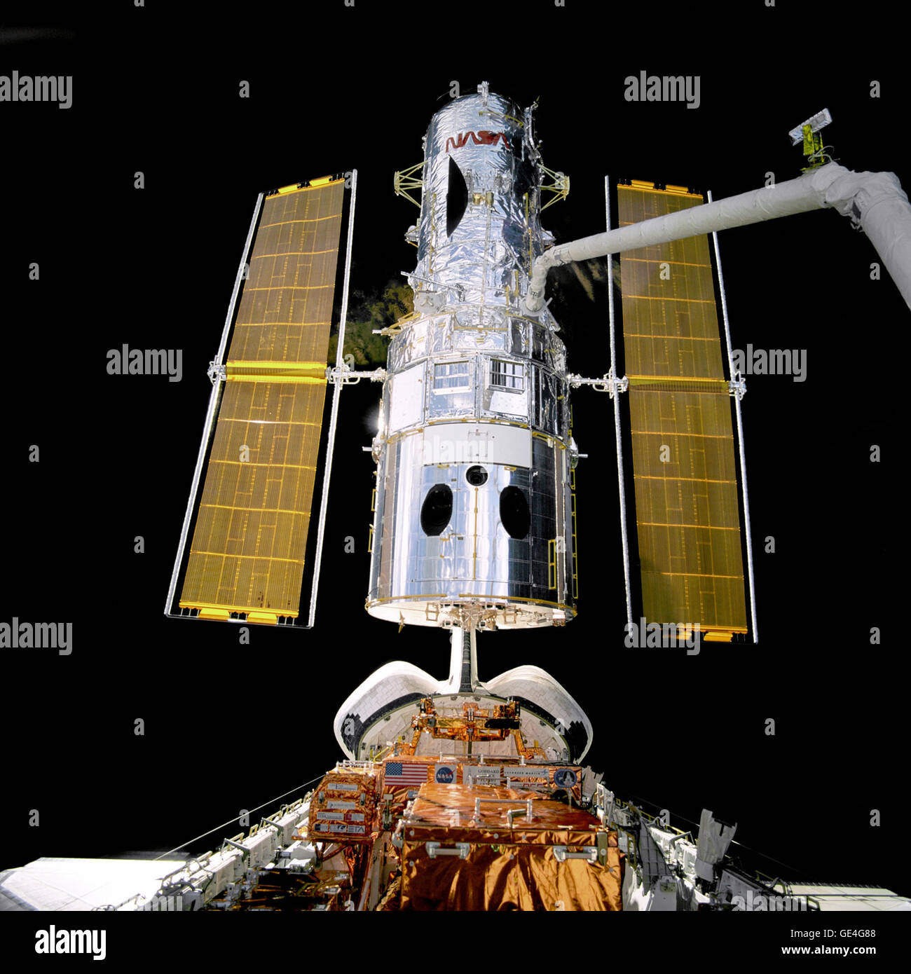 Attached to the &quot;robot arm&quot; the Hubble Space Telescope is unberthed and lifted up into the sunlight during this the second servicing mission designated HST SM-02.   Image # : STS082-709-097 Stock Photo