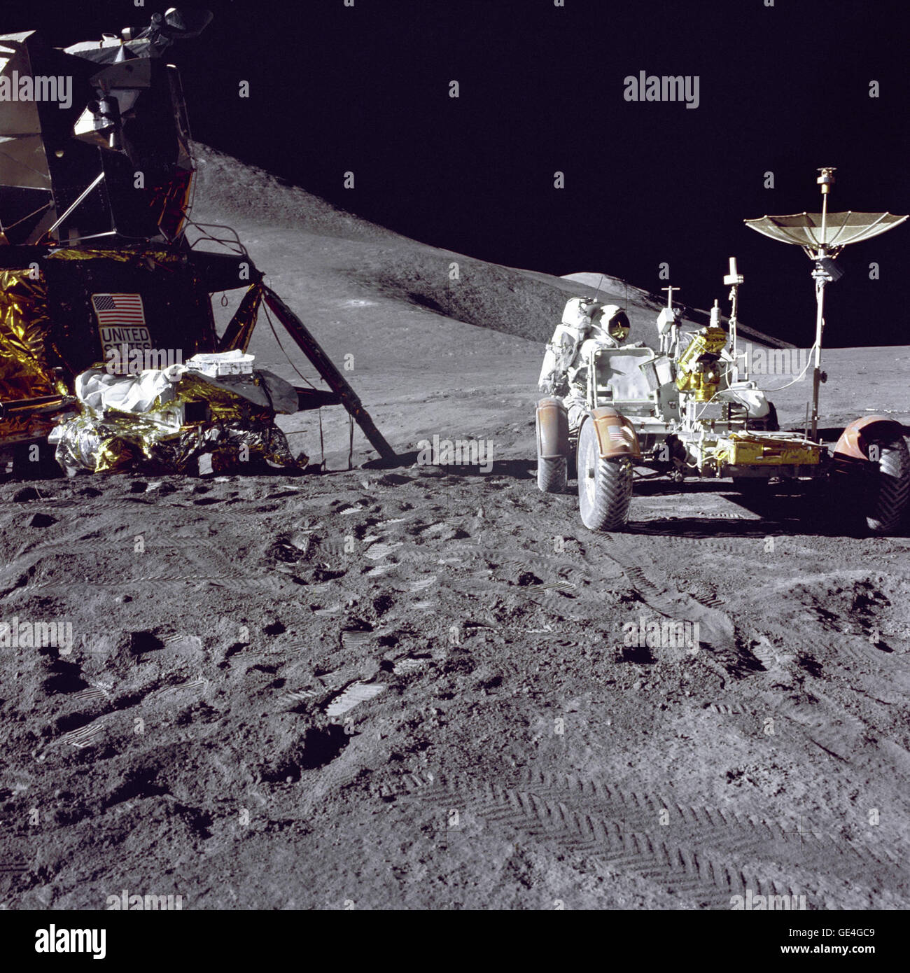 Apollo 15 Lunar Module pilot James B. Irwin loads-up the &quot;Rover&quot;, Lunar Roving Vehicle (LRV) with tools and equipment in preparation for the first lunar extravehicular activity (EVA-1) at the Hadley-Apennine landing site. A portion of the Lunar Module (LM) &quot;Falcon&quot; is on the left. The undeployed Laser Ranging Retro-Reflector (LR-3) lies atop the LM's Modular Equipment Stowage Assembly (MESA). This view is looking slightly West of South. Hadley Delta and the Apennine Front are in the background to the left. St. George crater is approximately 5 kilometers (about 3 statute mil Stock Photo
