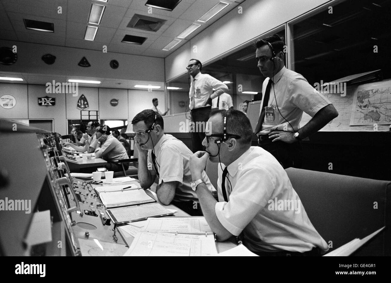 View of activity at the flight director's console in the Mission Operations Control Room in the Mission Control Center, Building 30, on the first day of the Apollo 10 lunar orbit mission. Seated are Gerald D. Griffin (foreground) and Glynn S. Lunney, Shift 1 (Black Team) flight directors. Milton L. Windler, standing behind them, is the flight director of Shift 2 (Maroon Team). In the center background, standing, is Dr. Christopher C. Kraft Jr., MSC Director of Flight Operations.   Photo Number: S69-34038 Date: May 18, 1969 Stock Photo