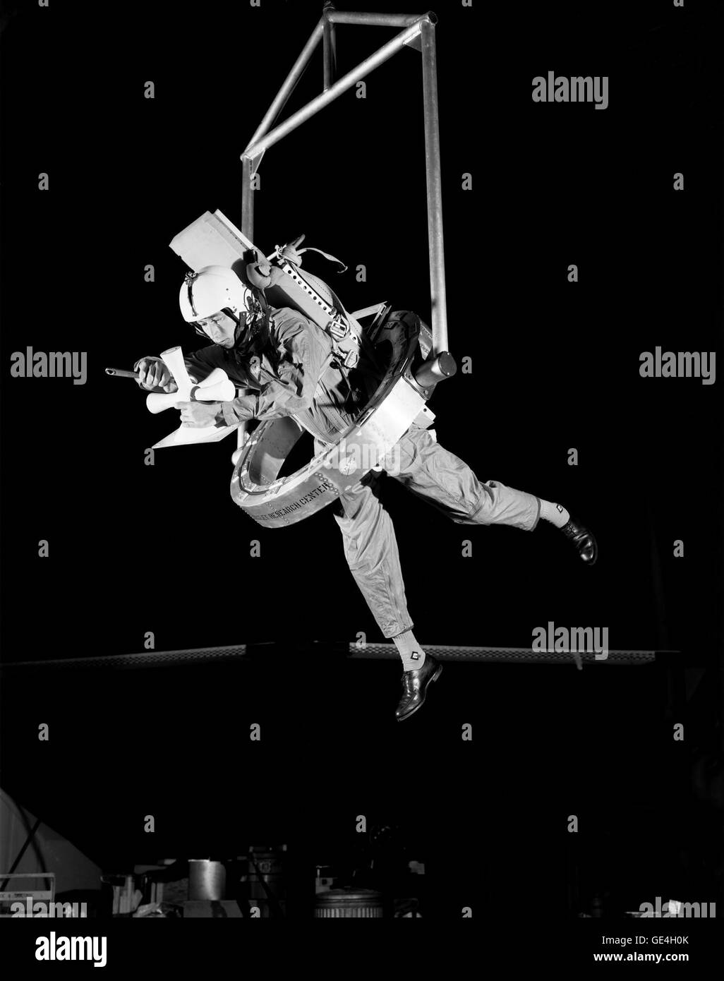 OMEGA (One-Man Extravehicular Gimbal Arrangement) shown here permits unlimited freedom, and was designed around a parallel pair of 32-inch-diameter thin-line angular-contact bearings with half the balls removed to minimize friction. Tests were conducted with OMEGA subjects in flight suits and pressure suits to determine the best gimbal restraint system and operation techniques. The test subjects were suspended in a sling support from a single RDS cable. As they translate about, the RDS tracks them, keeping the cable vertical. The test subjects operate in an effectively zero-g environment in th Stock Photo