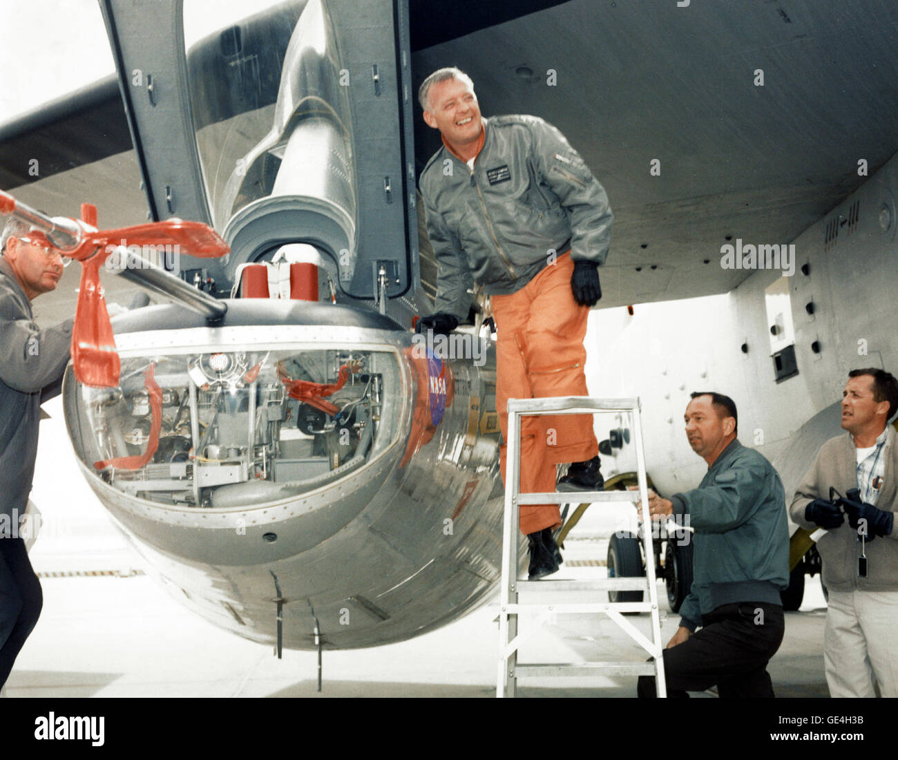 Jay L. King, Joseph D. Huxman and Orion D. Billeter assist NASA research pilot Milt Thompson (on the ladder) into the cockpit of the M2-F2 lifting body research aircraft at the NASA Flight Research Center (now the Armstrong Flight Research Center). The M2-F2 is attached to a wing pylon under the wing of NASA's B-52 mothership.   Image # : EC66-1154 Date: February 1, 1966 Stock Photo