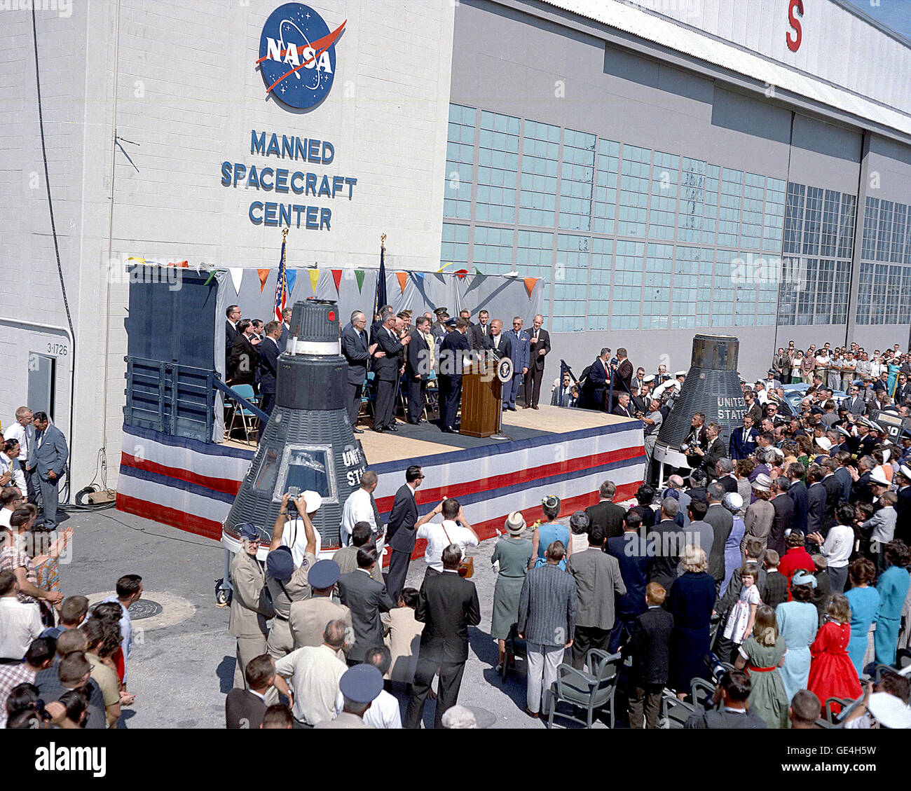 President John F. Kennedy honors astronaut John Glenn at Cape Canaveral on February 23, 1962.  This welcoming ceremony came immediately after Glenn's historic 3 orbit mission in Friendship 7.  Glenn was the first American to orbit the Earth on that mission.  James Modarelli’s NASA insignia (affectionately known as the &quot;Meatball&quot;) is proudly displayed on Hangar S. The hangar was the home for the Mercury Program at Cape Canaveral.  It included processing facilities for the Mercury spacecraft, training facilities, offices and sleeping quarters for the astronauts.    Image #: KSC-62PC-00 Stock Photo