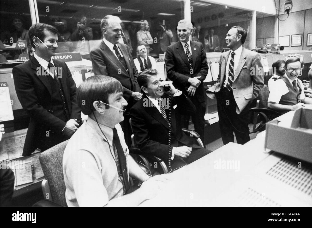 President Ronald Reagan gets a laugh from NASA officials in Mission Control when he jokingly asks crew members, astronauts Joe Engle and Richard Truly if they could stop by Washington en route to their California landing site in order that he might come along. The STS-2 crew was in their next to last day on orbit when the conversation took place. From left to right standing: Terry J. Hart, NASA Deputy Administrator Dr. Hans Mark, NASA Administrator James M. Beggs, JSC Director Dr. Christopher C. Kraft Jr. From left to right seated: CAPCOM, Astronaut Daniel C. Brandenstein President, Ronald Rea Stock Photo