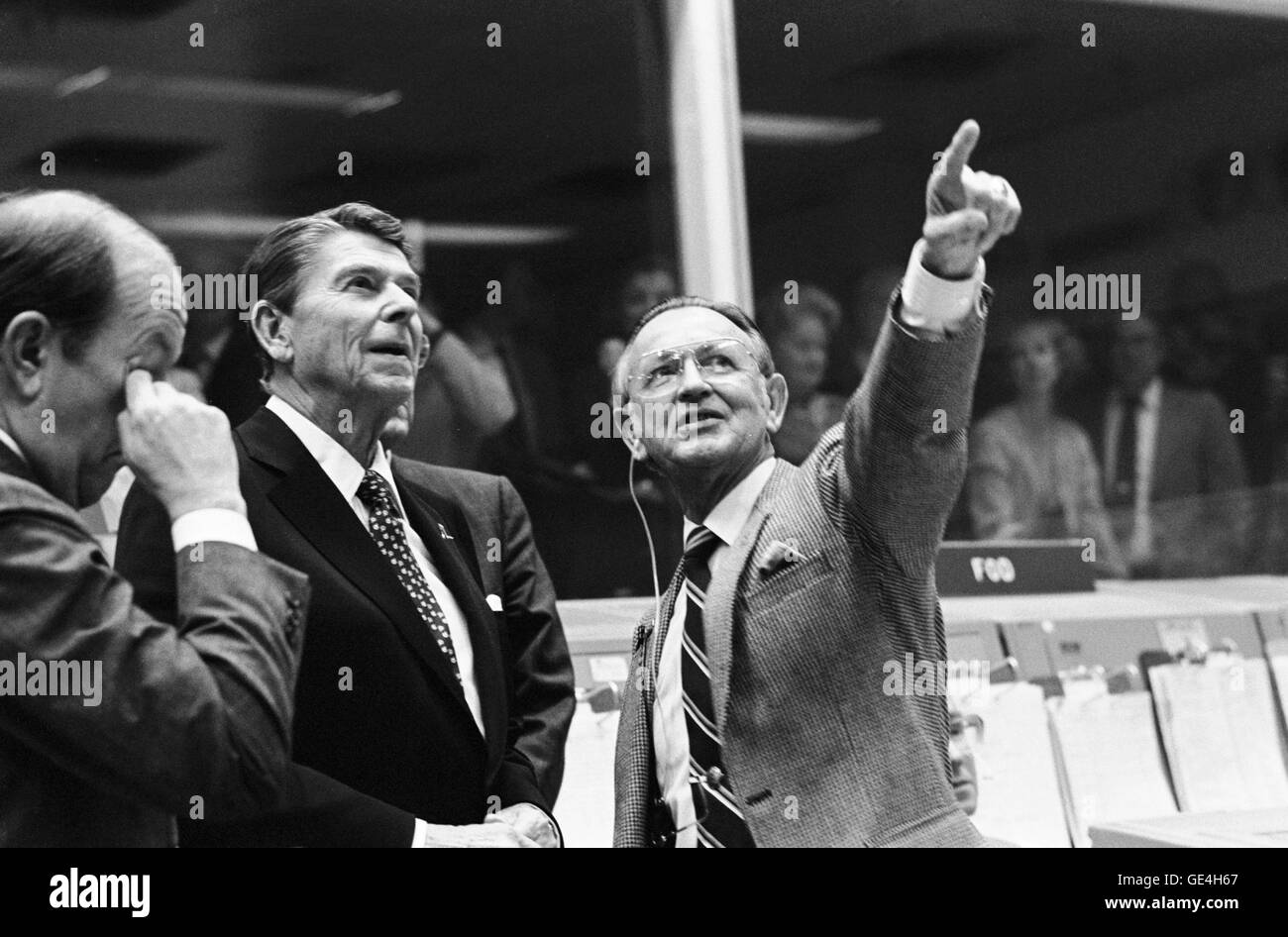 President Ronald Reagan is briefed by JSC Director Christopher C. Kraft Jr., who points toward the orbiter spotter on the projection plotter in the front of the mission operations control room in the Johnson Space Center's Mission Control Center. This picture was taken just prior to a space-to-ground conversation between STS-2 crew members Joe H. Engle and Richard H. Truly, who were orbiting Earth in the space shuttle Columbia.   Photo credit: NASA  Photo Number: S81-39499  Date: November 13, 1981 Stock Photo