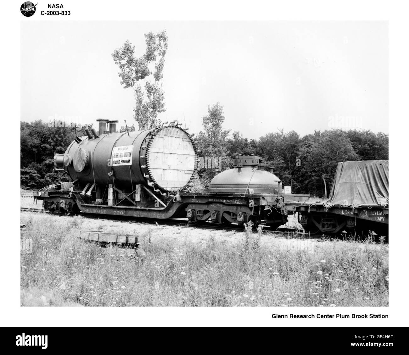 The pressure tank was shipped to Plum Brook via railway, and transported to the reactor facility on a flatbed truck. The tank was then rolled to a crane, which lifted it into place at the center of the unfinished quadrant area. Several pipes jutted out from the tank. These &quot;test holes&quot; would be used to transport experiments to the reactor core for radiation during its operating cycles.  Image #: C-2003-833 Stock Photo