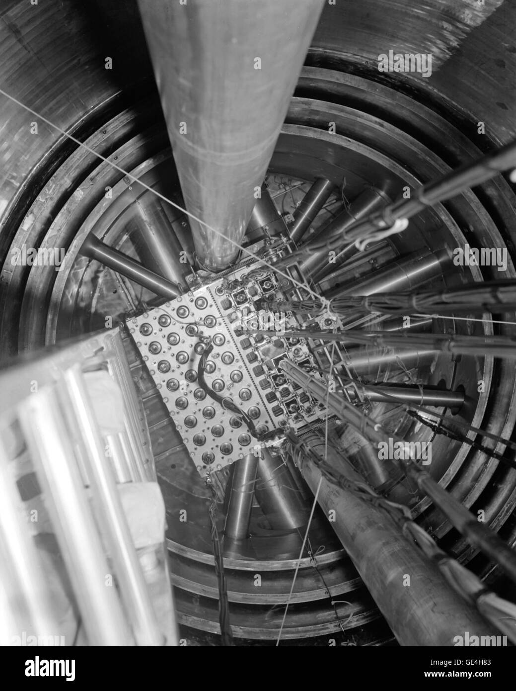 The reactor core area from the top of the pressure tank. The reactor core (right side of the box) comprises a uranium-fueled section (a center array of three hole by nine holes for fuel control rods) surrounded by reflector material or experiments, to compose the complete four-by-eleven hole core array. The fueled core contains twenty-two stationary rods and five movable cadmium and fuel control rods. The reflector material on three sides includes two cadmium and beryllium movable regulating rods, three similar shim safety rods, and twelve fixed reflector plugs or experiments. The fueled core  Stock Photo