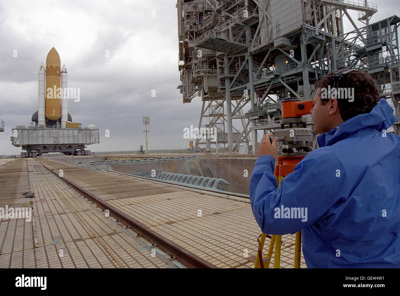 Ed Muktarian, a structural engineer with Lockheed Space Operations Co., is assisting with the docking of the Space Shuttle Endeavour at Launch Pad 39B. Muktarian is using a surveying instrument called a zenith nadir plummet to properly align survey plates located both on the pad surface and the mobile launch platform (MLP), which rests atop the crawler and supports the Shuttle. The north-south positioning provided by the plummet is used in conjunction with the east-west alignment accomplished with the highly precise laser docking system on the crawler. Muktarian communicates through his headse Stock Photo
