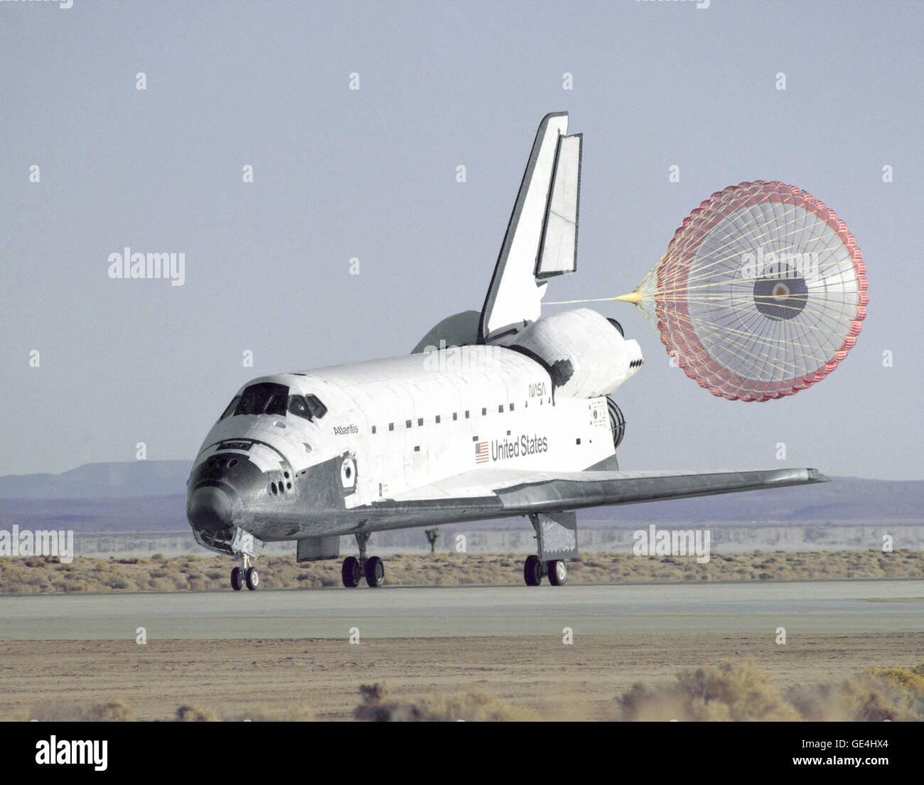 The Space Shuttle Atlantis lands with its drag chute deployed on runway 22 at Edwards, California, to complete the STS-66 mission dedicated to the third flight of the Atmospheric Laboratory for Applications and Science-3 (ATLAS-3), part of NASA's Mission to Planet Earth program. The astronauts also deployed and retrieved a free-flying satellite designed to study the middle and lower thermospheres and perform a series of experiments covering life sciences research and microgravity processing. The landing was at 7:34 a.m. (PST) November 14, 1994, after being waved off from the Kennedy Space Cent Stock Photo