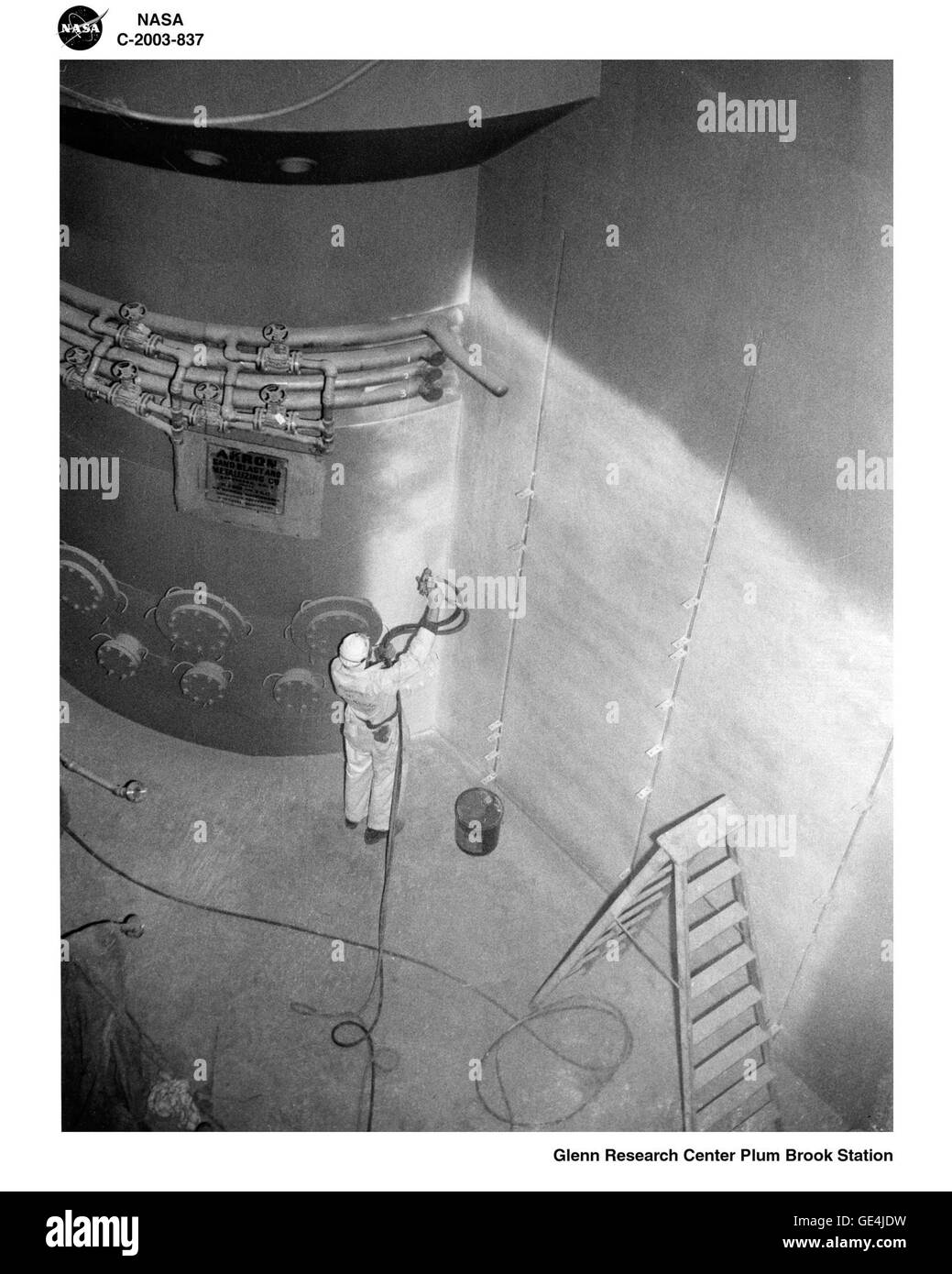 A worker spray paints one of the quadrant walls and a shielding wall surrounding the reactor pressure tank. The quadrants were twenty-five to twenty-seven feet deep and filled with water. The water provides shielding for the radioactive materials that were transported along the canal basin.  Image # : C-2003-837 Stock Photo