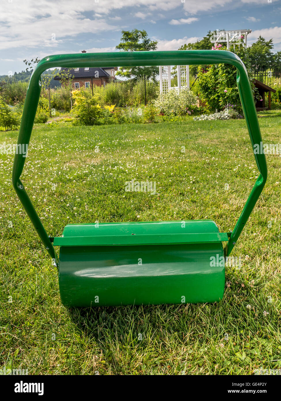 Green lawn roller ready to roll the garden lawn Stock Photo
