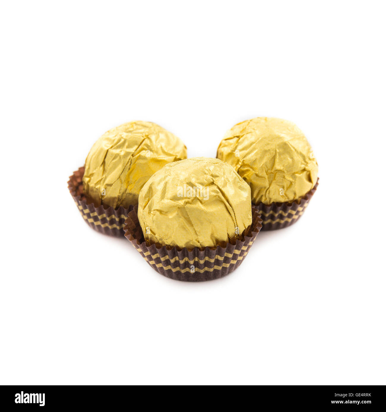 Sweet chocolate balls with almond wrapped in gold foil paper on white