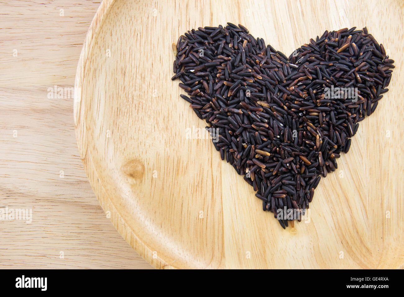 Heart rice berry in wooden bowls on wooden background. concept Stock Photo