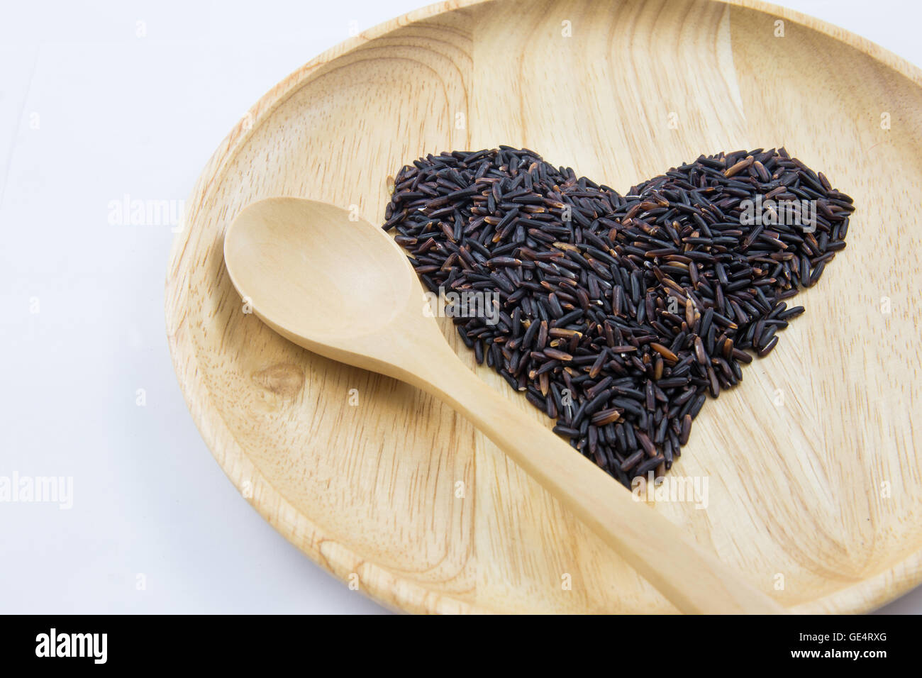 Heart rice berry in wooden bowls with spoon on wooden background. concept Stock Photo