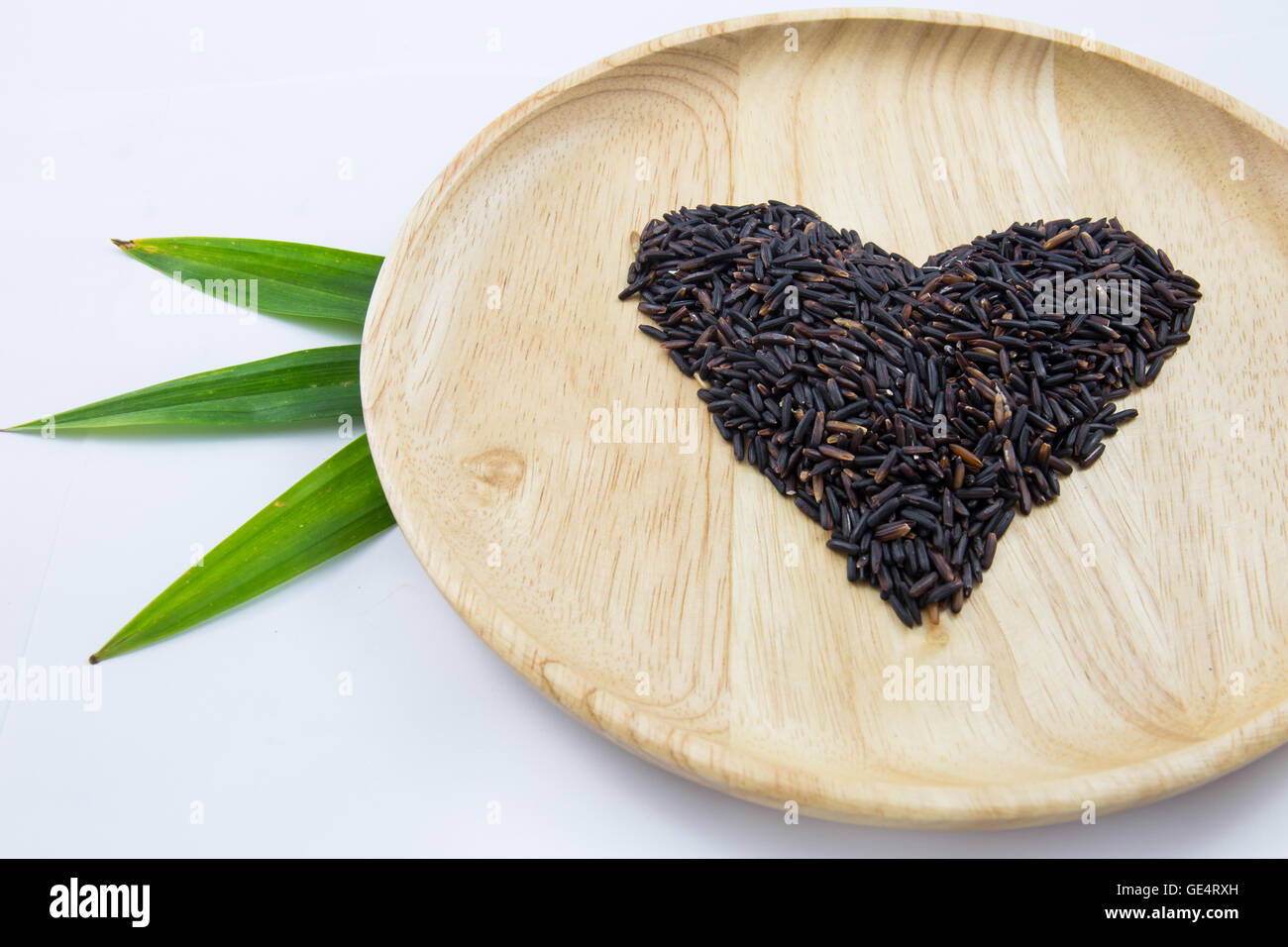 Heart rice berry in wooden bowls and green pandan on white background ...