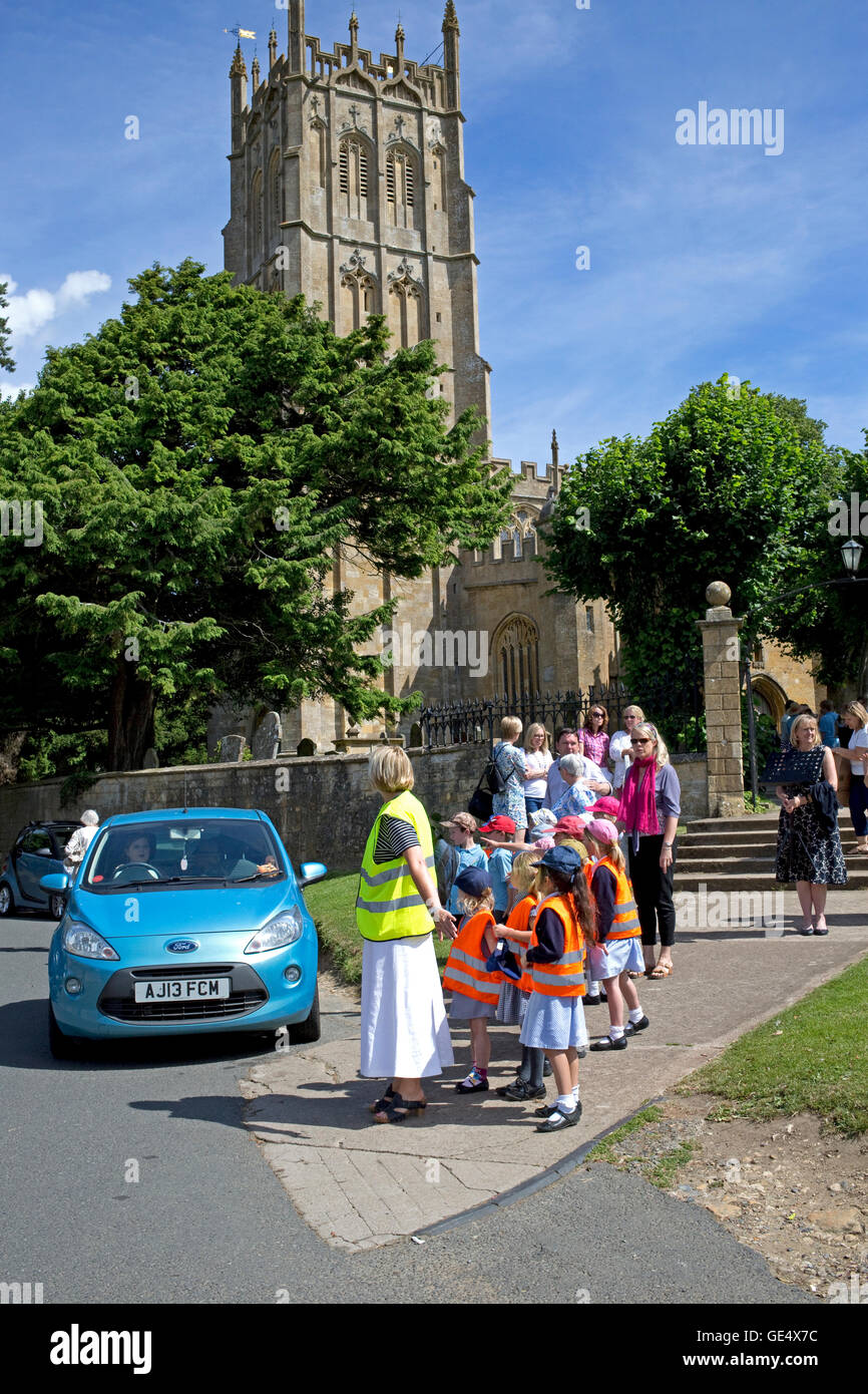 Teacher and children preparing to cross road Chipping Campden UK Stock Photo