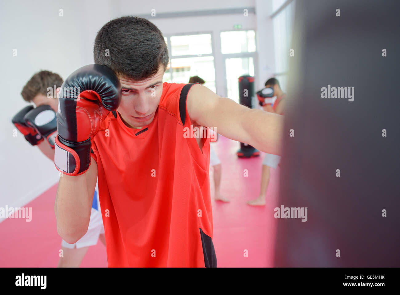 young man punching a punching bag Stock Photo Alamy
