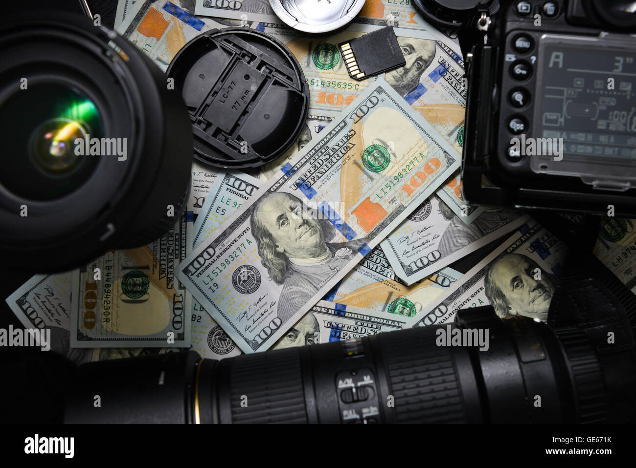 Background American one hundred dollar bills and DSLR camera devices. Making a lot of money by DSLR camera, Success business con Stock Photo