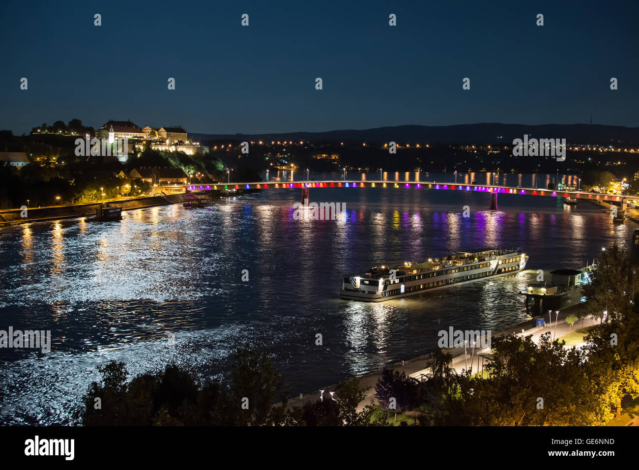 Petrovaradin fortress and 'Rainbow bridge' over the Danube, between Novi Sad and Petrovaradin in the moonlight with ship docking Stock Photo