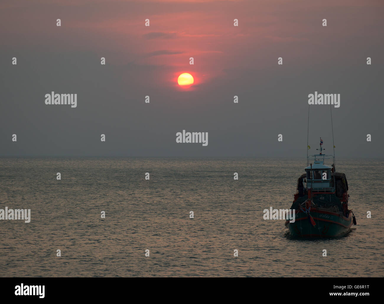 golden sunset over sea and sky with fishing boat Stock Photo - Alamy