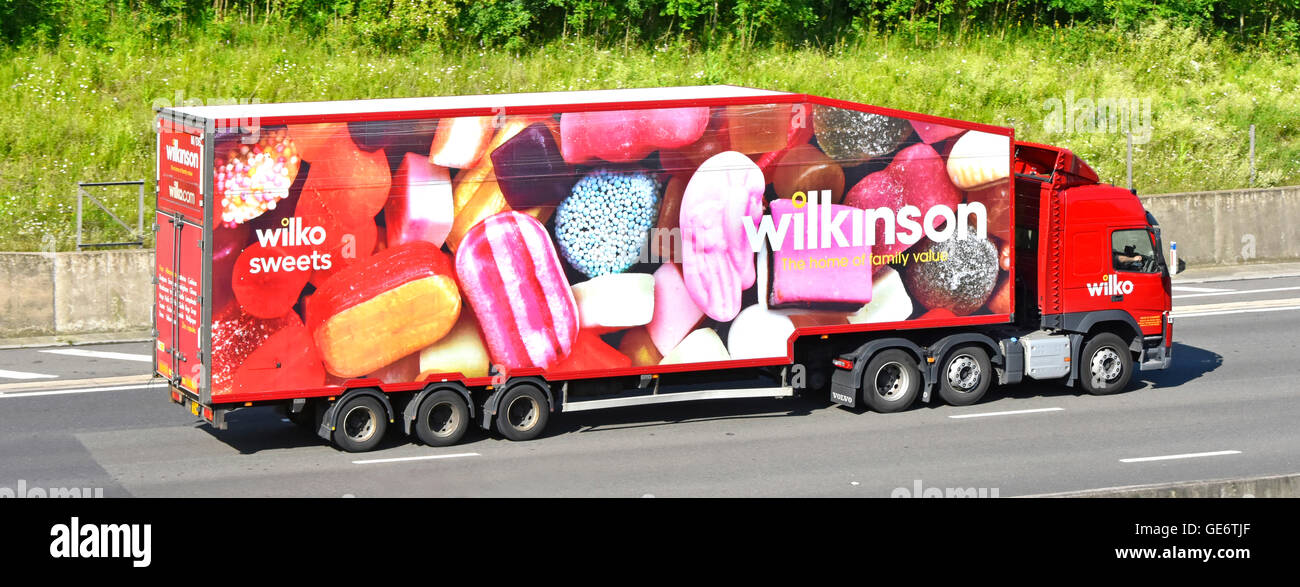 UK English motorway Wilkinson supply chain logistics via hgv articulated lorry & streamlined trailer with colourful Wilko graphics depicting sweets Stock Photo