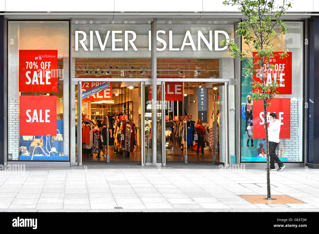 Sale discount posters in store windows at River Island clothing shop front & entrance in Oxford Street West End  London shopping street in England UK Stock Photo