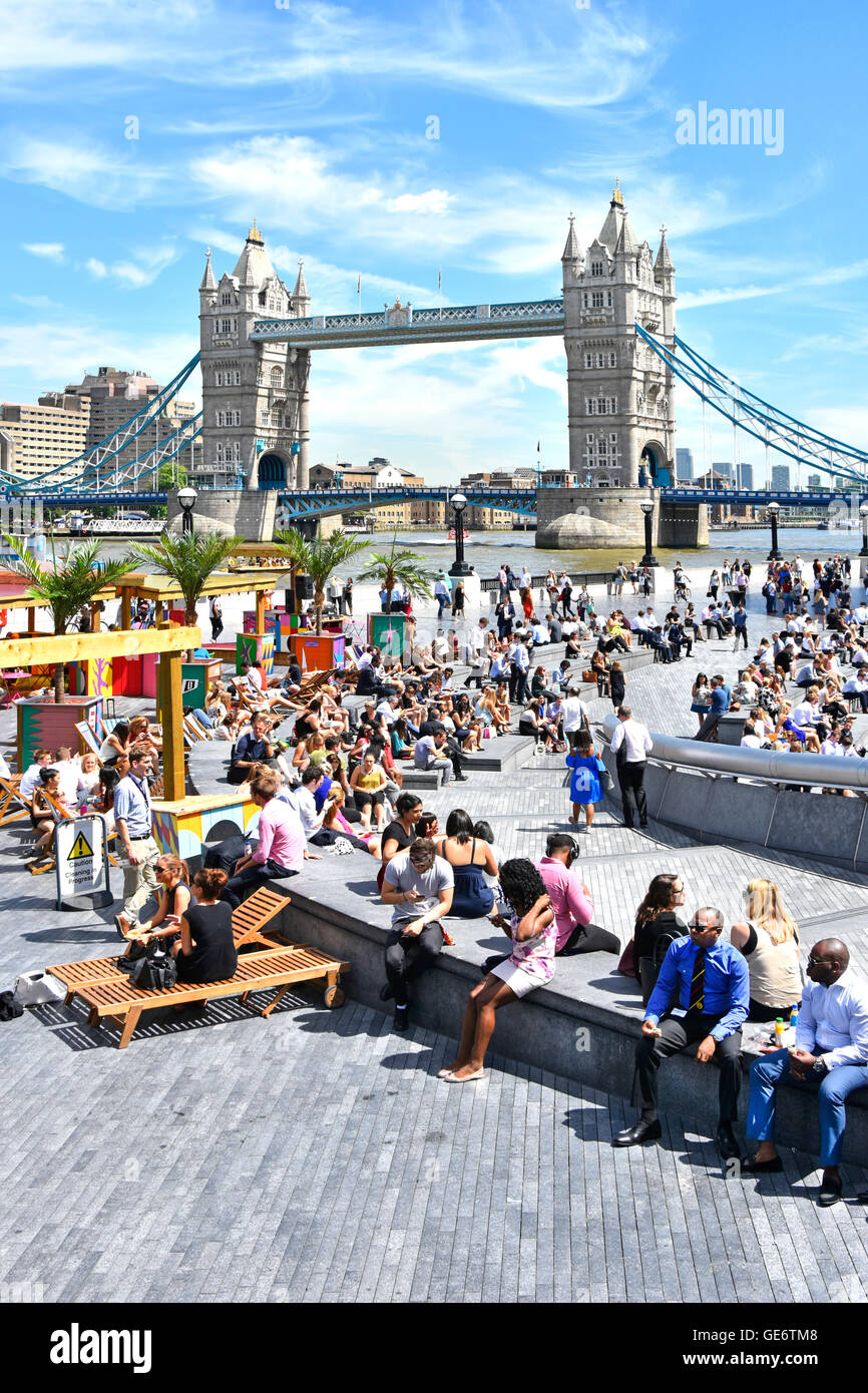 Hot day for office workers & tourists summertime drinks & food stalls at 'The Scoop' beside More London & Tower Bridge England UK on River Thames Stock Photo