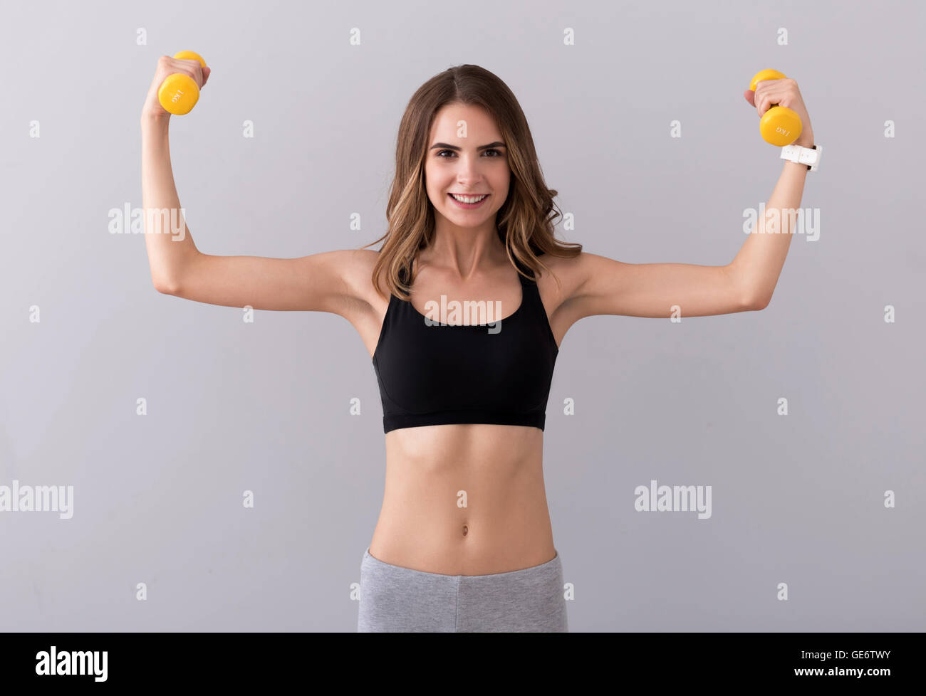 Nice smiling woman practicing with dumb bells Stock Photo