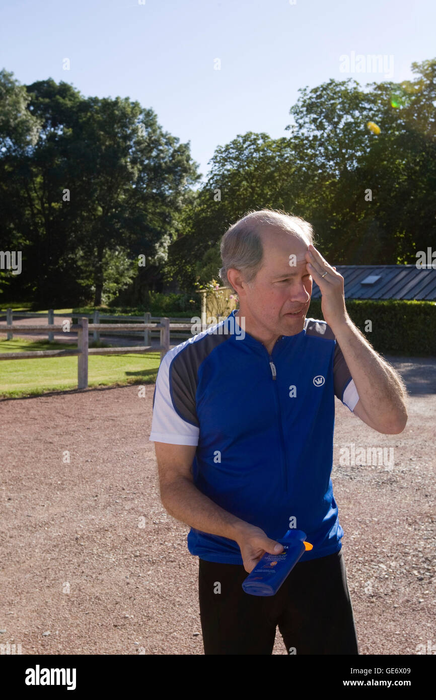 Larry Athan, participant in a Backroads cycle tour of the Loire Valley, applies sunscreen before setting off on the day 3 ride, at the Stock Photo