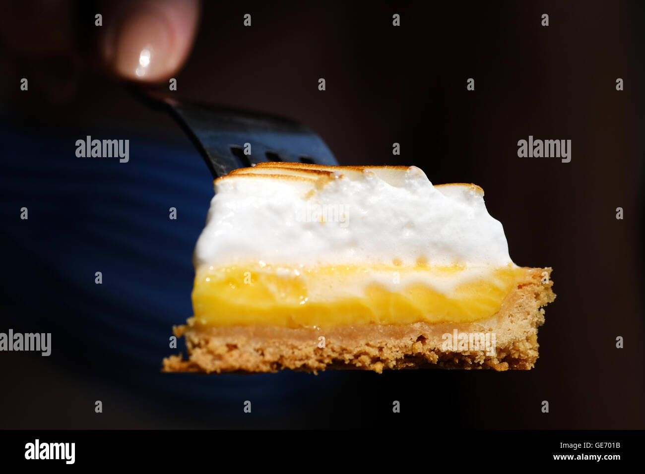 A delicious looking slice of Lemon Meringue cake on a fork Stock Photo
