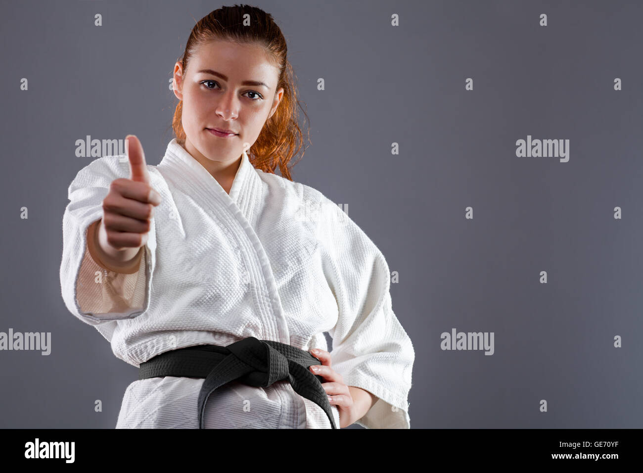 Woman Wearing Karate Kimono with Thumbs Up Stock Photo