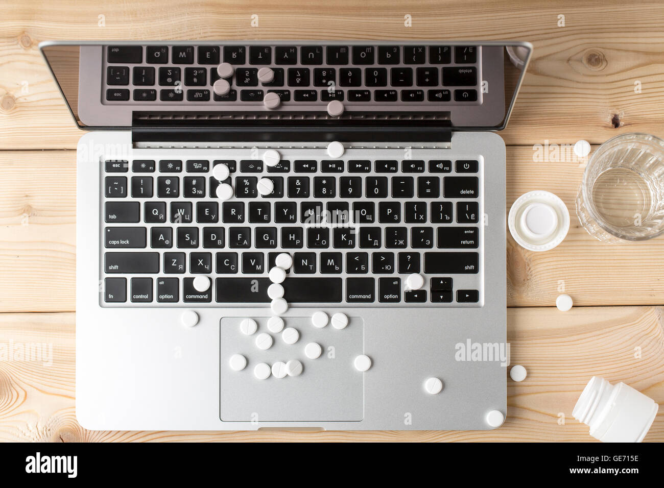 Heap of round white pills on the open laptop Stock Photo