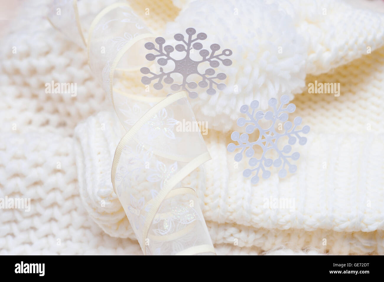 Warm woolen knitted hat and scarf with big white snowflakes Stock Photo