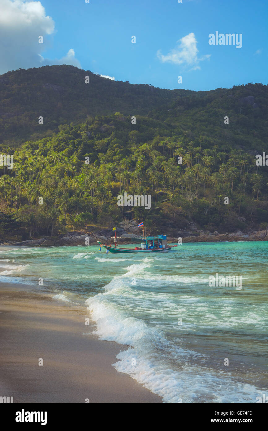 A boat is anchored at Bottle Beach, Koh Pha Ngan, Thailand Stock Photo