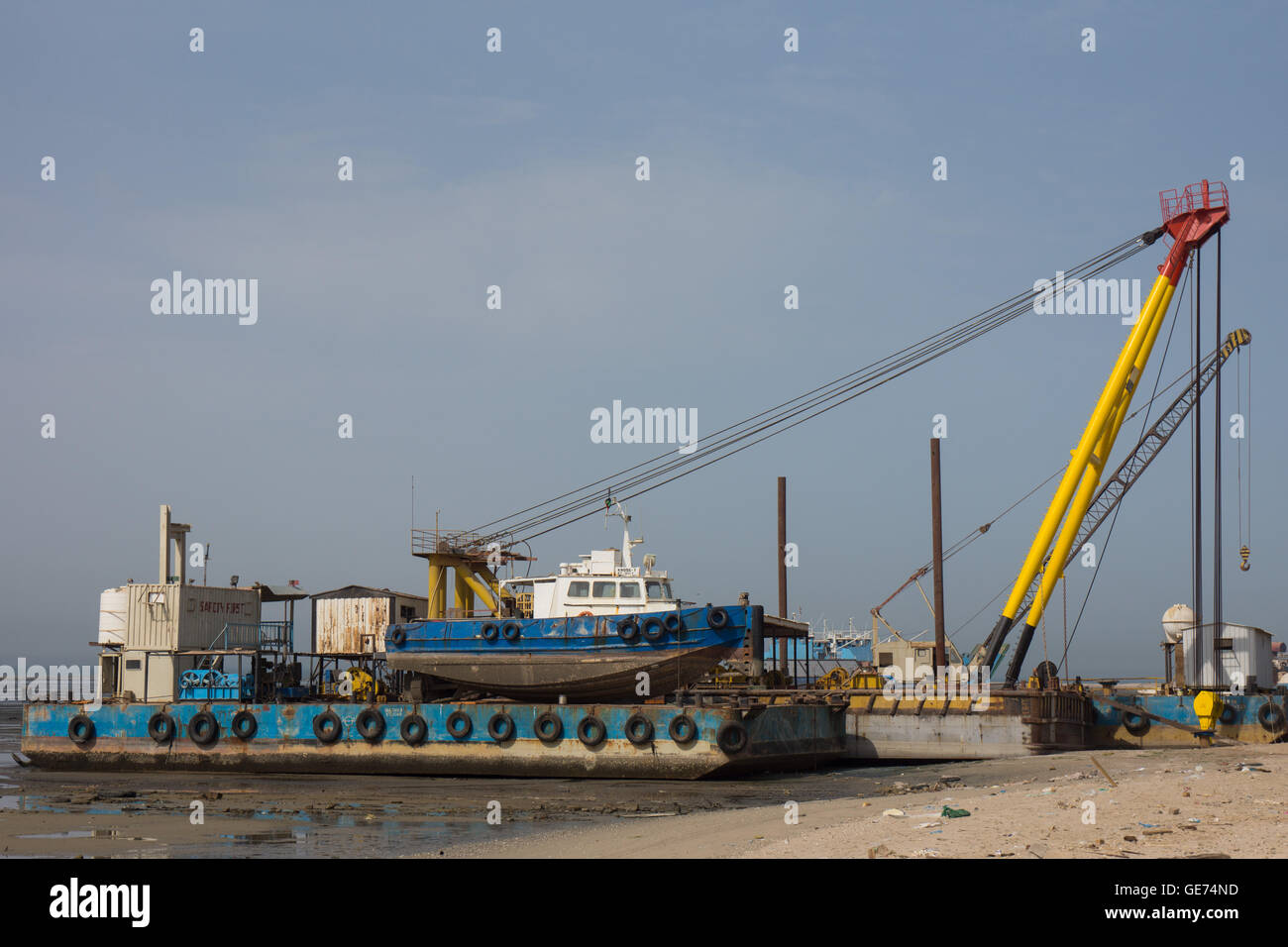 Sheerleg crane barge at a boat scrap yard Stock Photo
