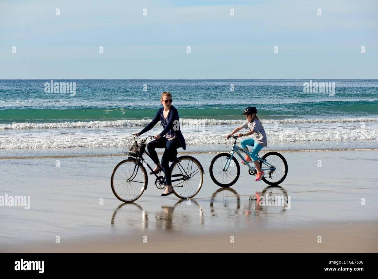Mother and Daughter riding bikes on beach, San Diego, California Stock