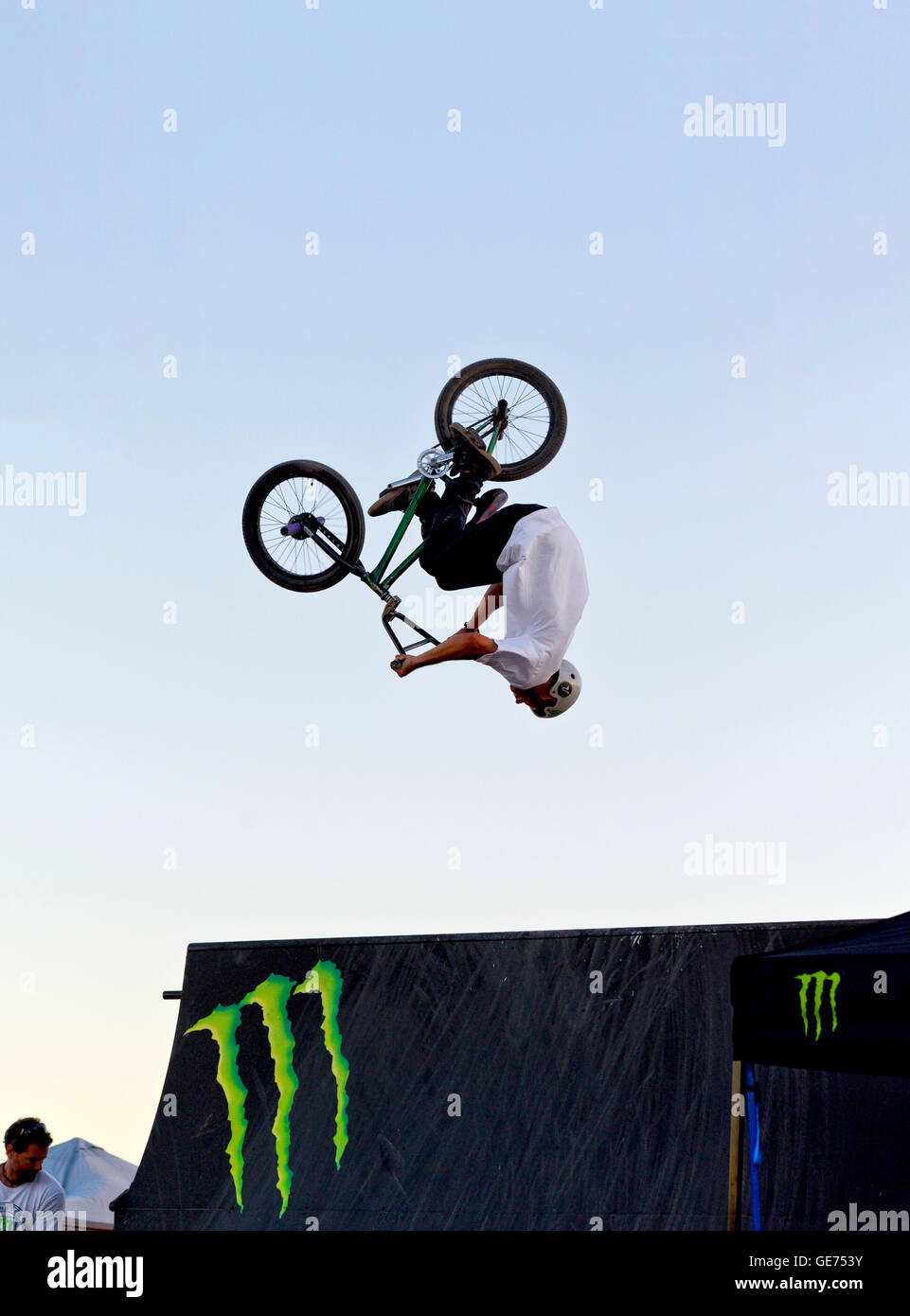 A person doing a back flip over a jump on a BMX bicycle Stock Photo