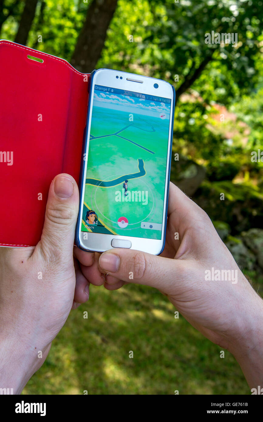 Person use a smartphone to play Pokemon Go Stock Photo