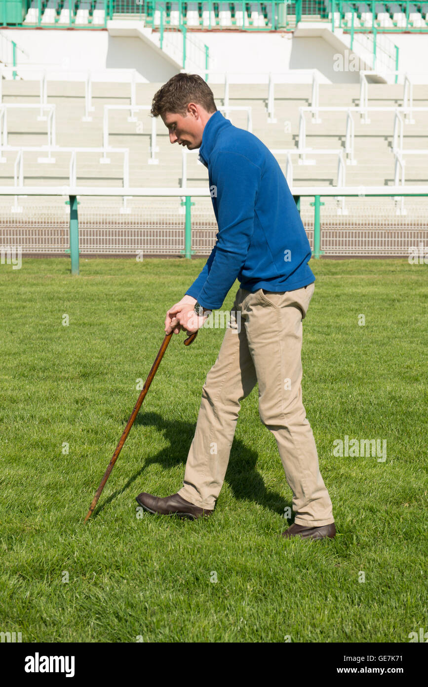 The head grounds man at Brighton Race course checks the ground & the going for the upcoming horse race with specialist equipment Stock Photo