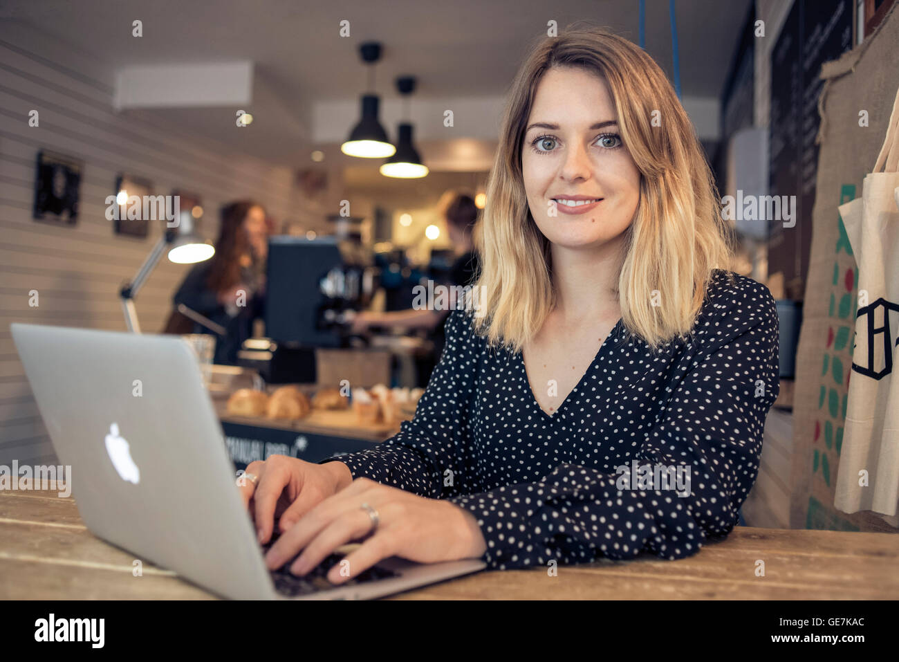 woman working on laptop in a coffee shop using the wifi in the modern ...