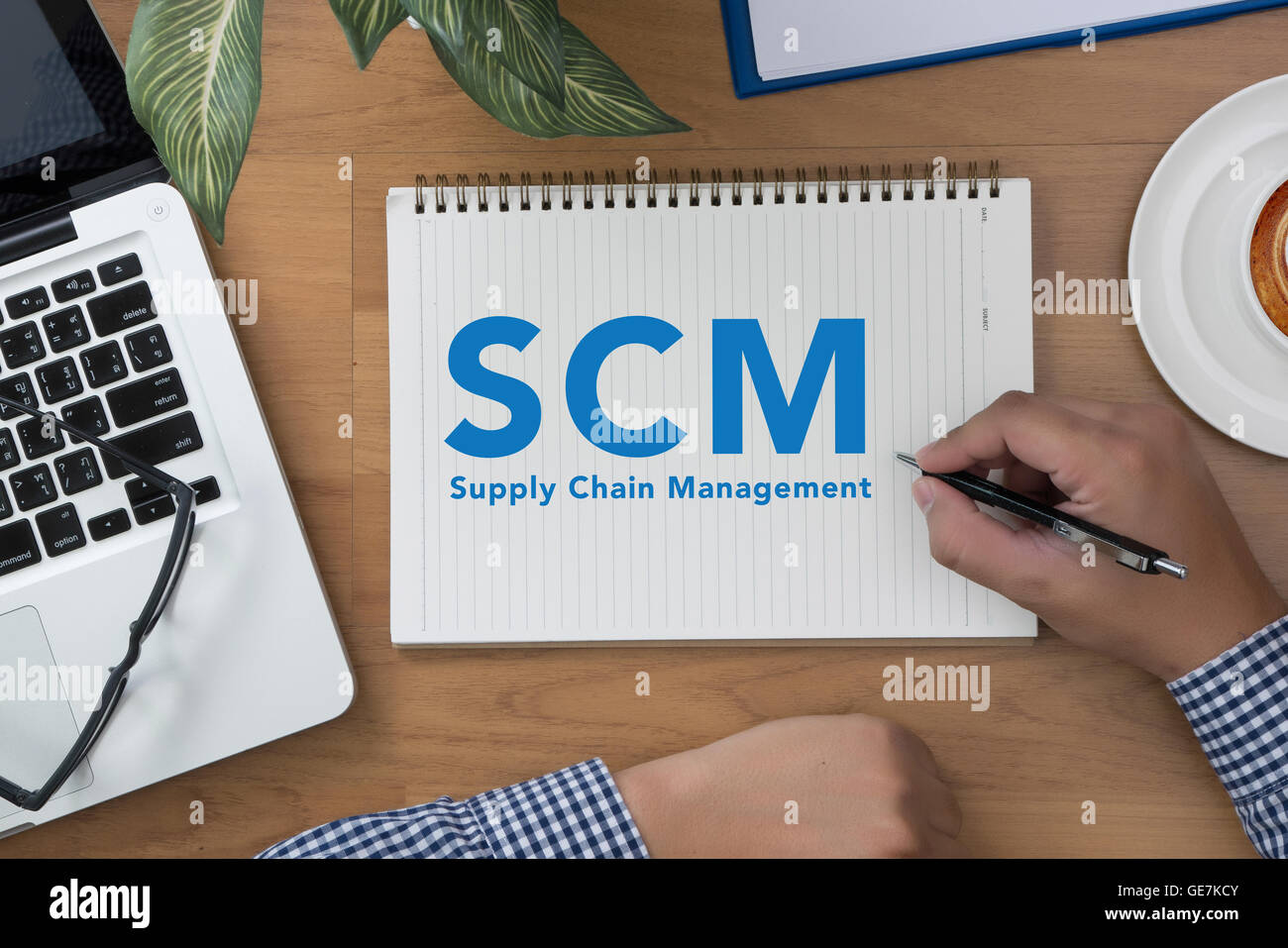 SCM Supply Chain Management concept man hand notebook and other office
