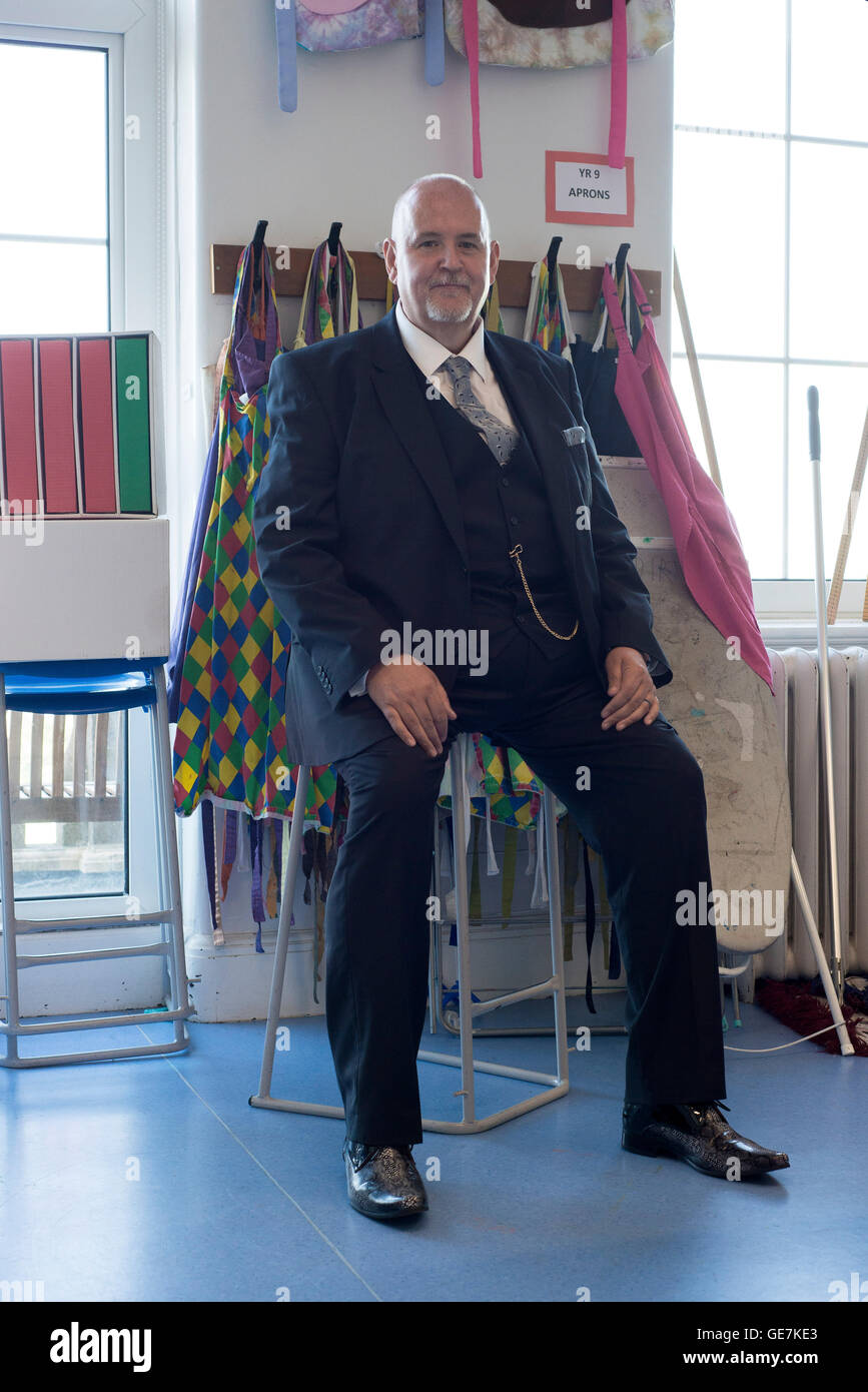 head teacher sits in classroom at their school for a formal posed