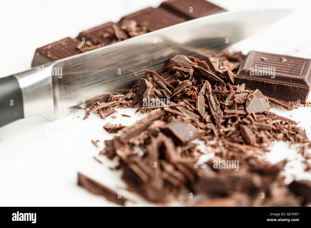 chocolate bar and shavings with a knife on white background Stock Photo