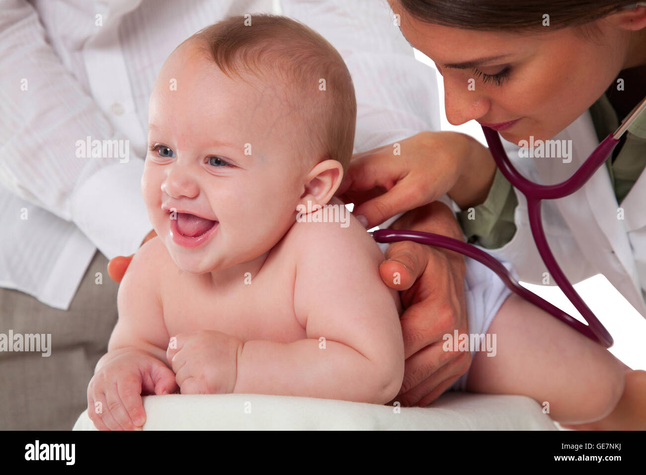A photo of female pediatrician examining baby boy being held by father Doctor listening to patient's back with stethoscope Toddl Stock Photo