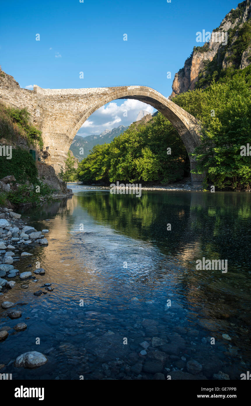 The old stone bridge across the Aoos river at Konitsa with Mount Tymfi in the background, Epirus, Northern Greece. Stock Photo